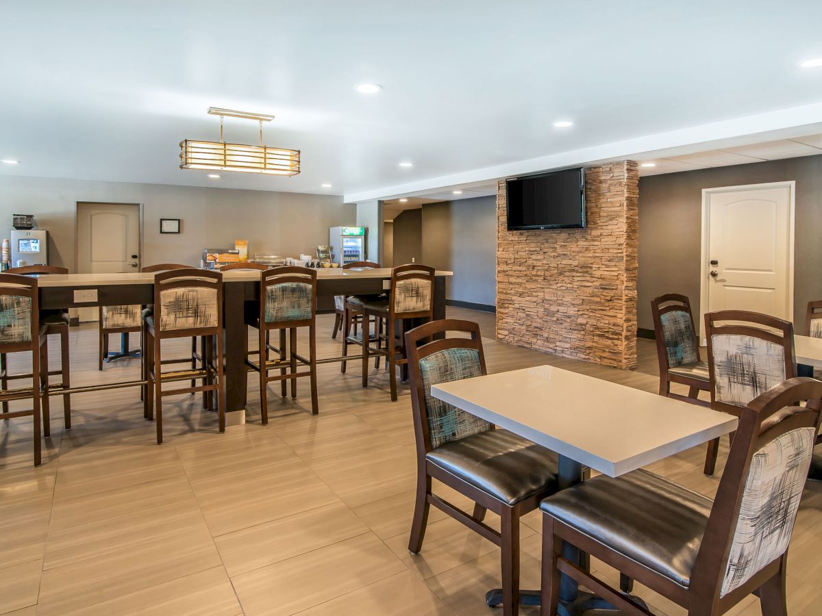 An indoor dining area with tables and chairs, a TV on the wall, and various dining-related furniture and decor.